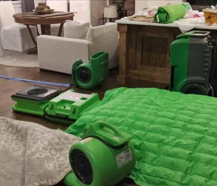 Bright green SERVPRO drying equipment in home